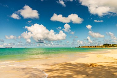 Beyaz kumlu Karayip plajı, derin mavi gökyüzü ve turkuaz su