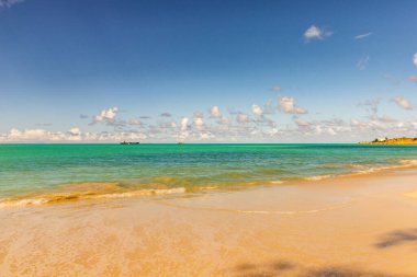 Beyaz kumlu Karayip plajı, derin mavi gökyüzü ve turkuaz su