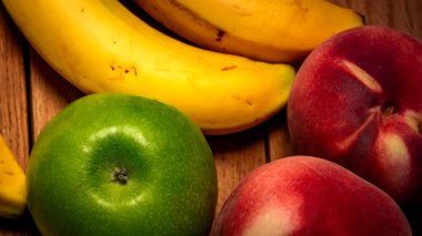 Tahtada elma, şeftali ve muz. Sağlıklı meyvelerin bileşimi.