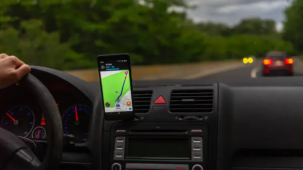 stock image Smartphone showing Waze maps to show the way thru the city. Driver using Waze maps