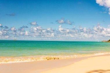 Beyaz kumlu Karayip plajı, derin mavi gökyüzü ve turkuaz su