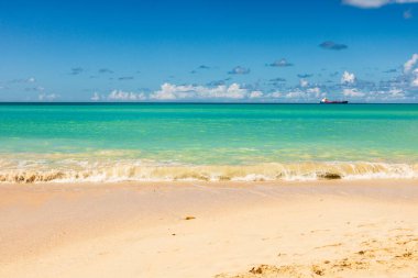 Beyaz kumlu Karayip plajı, derin mavi gökyüzü ve turkuaz su