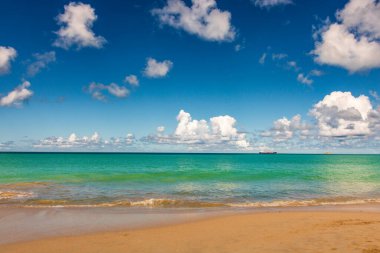Beyaz kumlu Karayip plajı, derin mavi gökyüzü ve turkuaz su