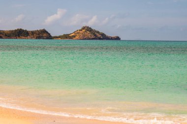 Beyaz kumlu Karayip plajı, derin mavi gökyüzü ve turkuaz su