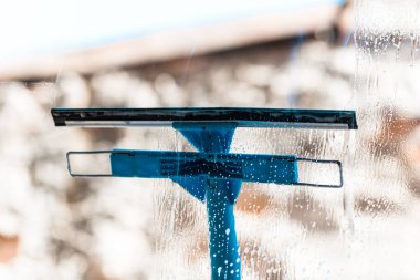 Pencereyi temizleyen adam cam temizleyicisi, temizleyici sprey, temizlik hizmeti konsepti kullanıyor. Ev işleri ve ev idaresi kavramı