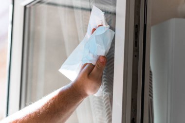 Camları kağıt havlularla silen adam, temizlik hizmeti konsepti. Ev işleri ve ev idaresi kavramı