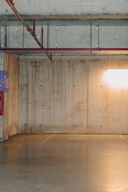 Loş ışıklı boş bir otopark. Yeraltı otoparkı