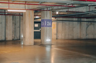 Loş ışıklı boş bir otopark. Yeraltı otoparkı