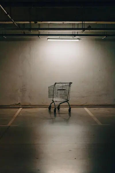 stock image Shopping car left at a parking lot. Underground parking garage