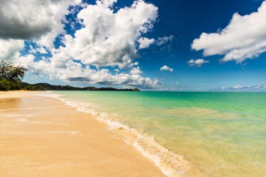 Beyaz kumlu Karayip plajı, derin mavi gökyüzü ve turkuaz su