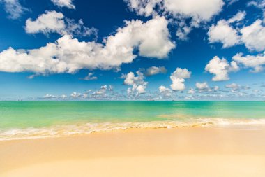 Beyaz kumlu Karayip plajı, derin mavi gökyüzü ve turkuaz su