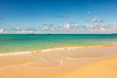 Beyaz kumlu Karayip plajı, derin mavi gökyüzü ve turkuaz su