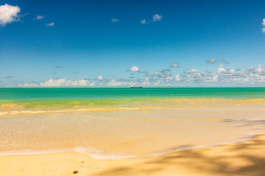 Beyaz kumlu Karayip plajı, derin mavi gökyüzü ve turkuaz su