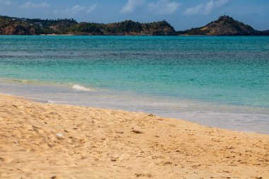 Beyaz kumlu Karayip plajı, derin mavi gökyüzü ve turkuaz su