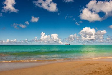 Beyaz kumlu Karayip plajı, derin mavi gökyüzü ve turkuaz su