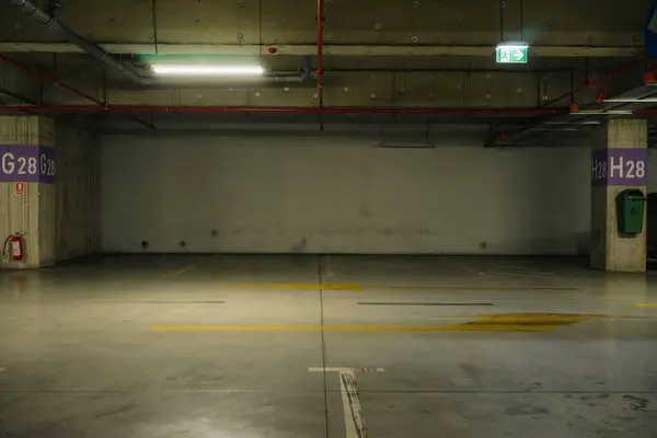 stock image Parking lot with overhead dim light, underground parking garage