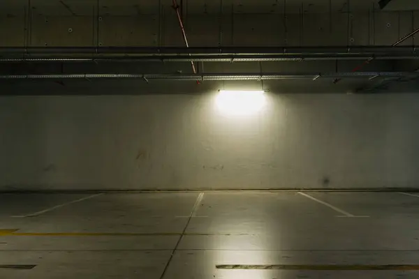 stock image Parking lot with overhead dim light, underground parking garage