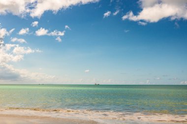Beyaz kumlu Karayip plajı, derin mavi gökyüzü ve turkuaz su