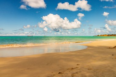 Beyaz kumlu Karayip plajı, derin mavi gökyüzü ve turkuaz su