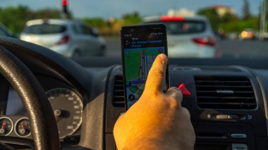 Smartphone showing Waze maps to show the way thru the city. Driver using Waze maps clipart