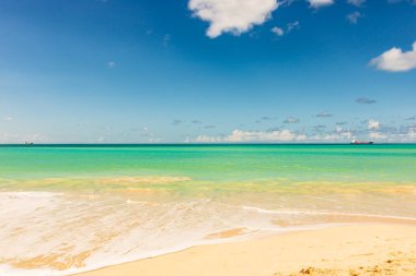 Beyaz kumlu Karayip plajı, derin mavi gökyüzü ve turkuaz su