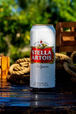 Stella Artois beer can - condensation water droplets, outdoors background clipart