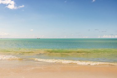 Beyaz kumlu Karayip plajı, derin mavi gökyüzü ve turkuaz su
