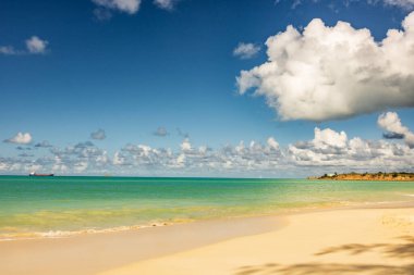 Beyaz kumlu Karayip plajı, derin mavi gökyüzü ve turkuaz su
