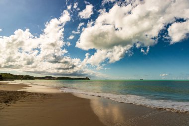 Beyaz kumlu Karayip plajı, derin mavi gökyüzü ve turkuaz su