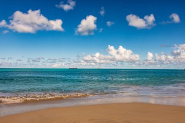 Beyaz kumlu Karayip plajı, derin mavi gökyüzü ve turkuaz su