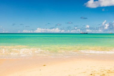 Beyaz kumlu Karayip plajı, derin mavi gökyüzü ve turkuaz su
