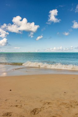 Beyaz kumlu Karayip plajı, derin mavi gökyüzü ve turkuaz su