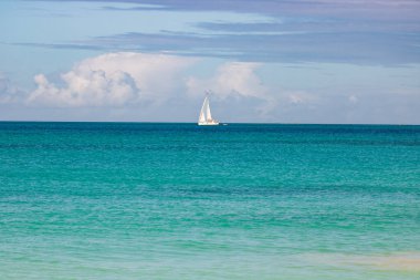 Beyaz kumlu Karayip plajı, derin mavi gökyüzü ve turkuaz su