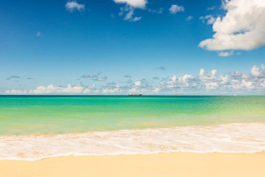 Beyaz kumlu Karayip plajı, derin mavi gökyüzü ve turkuaz su