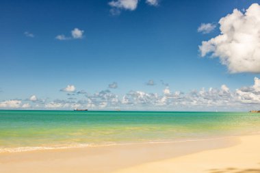 Beyaz kumlu Karayip plajı, derin mavi gökyüzü ve turkuaz su