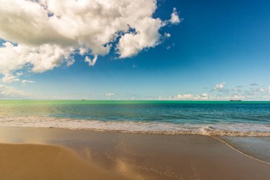 Beyaz kumlu Karayip plajı, derin mavi gökyüzü ve turkuaz su