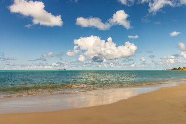 Beyaz kumlu Karayip plajı, derin mavi gökyüzü ve turkuaz su