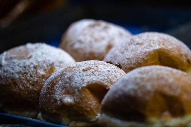 Bir sokak satıcısının vitrinine taze pişmiş hamur işleri konmuş.