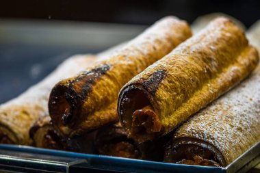 Bir sokak satıcısının vitrinine taze pişmiş hamur işleri konmuş.