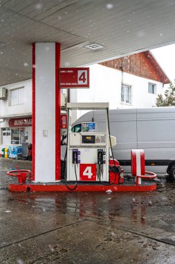LUKOIL benzin istasyonunun dışı. Benzin pompaları ve arabalar kar yağarken yakıt ikmali yapıyorlar.