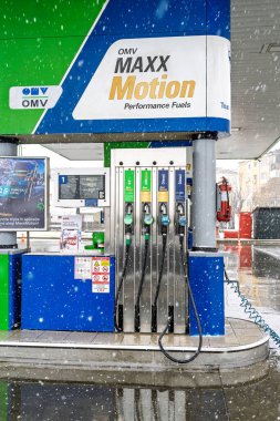 Bir OMV benzin istasyonunun dışı. Benzin pompaları ve arabalar kar yağarken yakıt ikmali yapıyorlar.