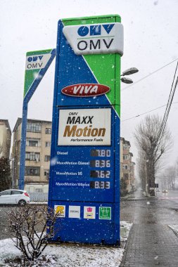 Bir OMV benzin istasyonunun dışı. Benzin pompaları ve arabalar kar yağarken yakıt ikmali yapıyorlar.