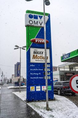 Bir OMV benzin istasyonunun dışı. Benzin pompaları ve arabalar kar yağarken yakıt ikmali yapıyorlar.
