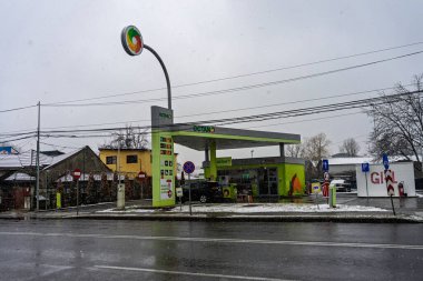 OCTANO benzin istasyonunun dışı. Benzin pompaları ve arabalar kar yağarken yakıt ikmali yapıyorlar.