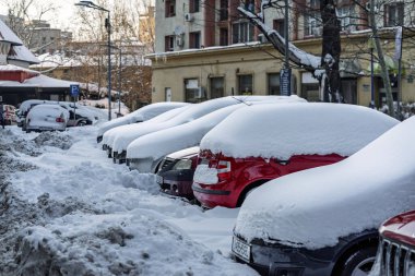 Kar yağdıktan sonra arabalara kar yağar. Kış manzarası ve karla kaplı arabalar