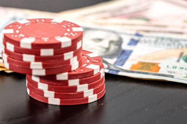 Siyah arka planda parası olan poker fişleri yığını, Amerikan Doları para birimi