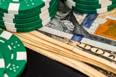 Siyah arka planda parası olan poker fişleri yığını, Amerikan Doları para birimi
