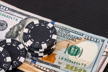 Siyah arka planda parası olan poker fişleri yığını, Amerikan Doları para birimi
