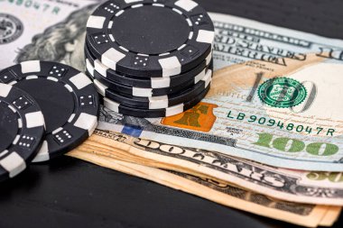 Siyah arka planda parası olan poker fişleri yığını, Amerikan Doları para birimi