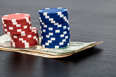 Siyah arka planda parası olan poker fişleri yığını, Amerikan Doları para birimi